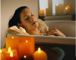 Picture 18 of a woman reclining relaxing in a bathtub with candles in the foreground